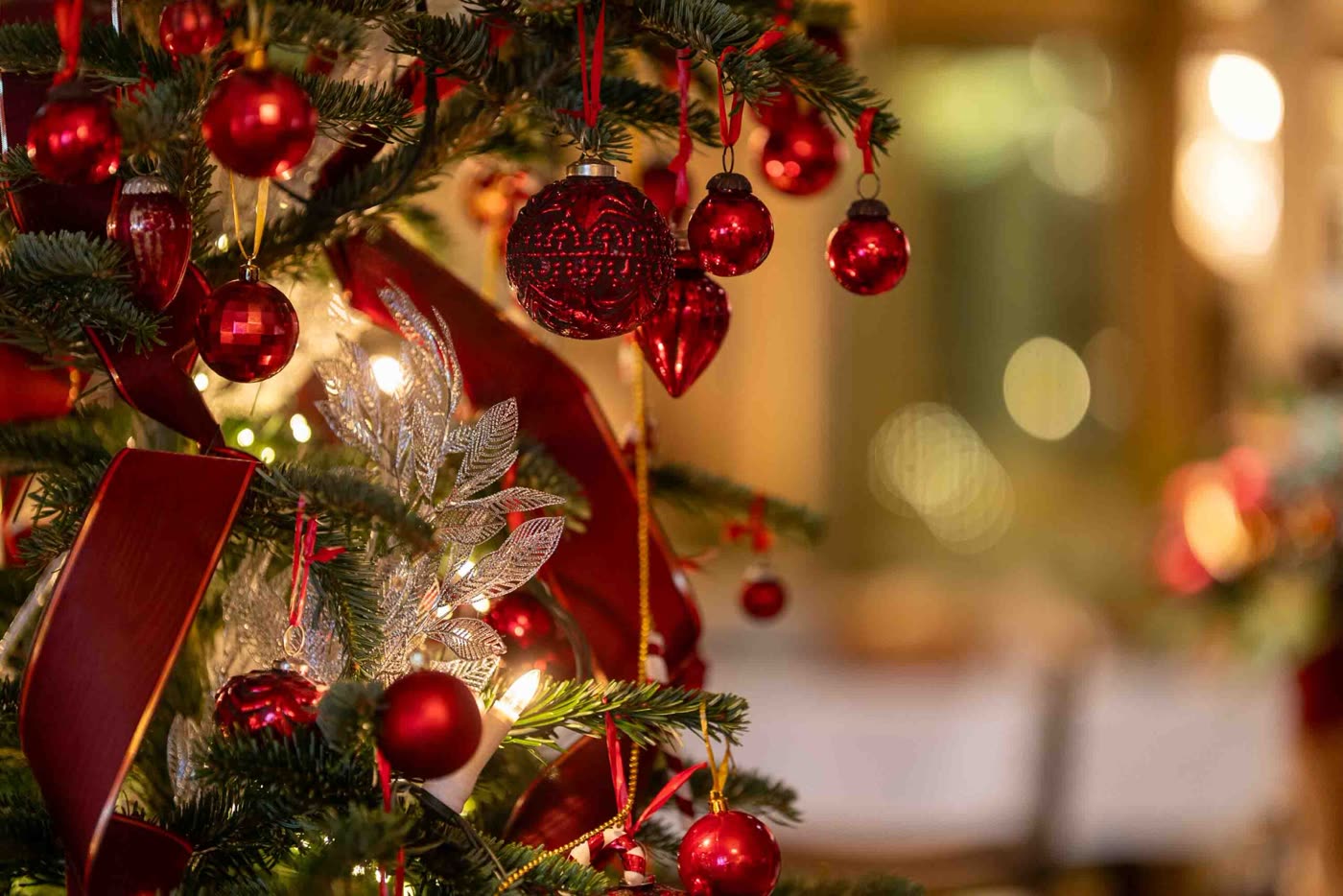 Närbild på julgran med röda kulor och siden i Säröhus lobby